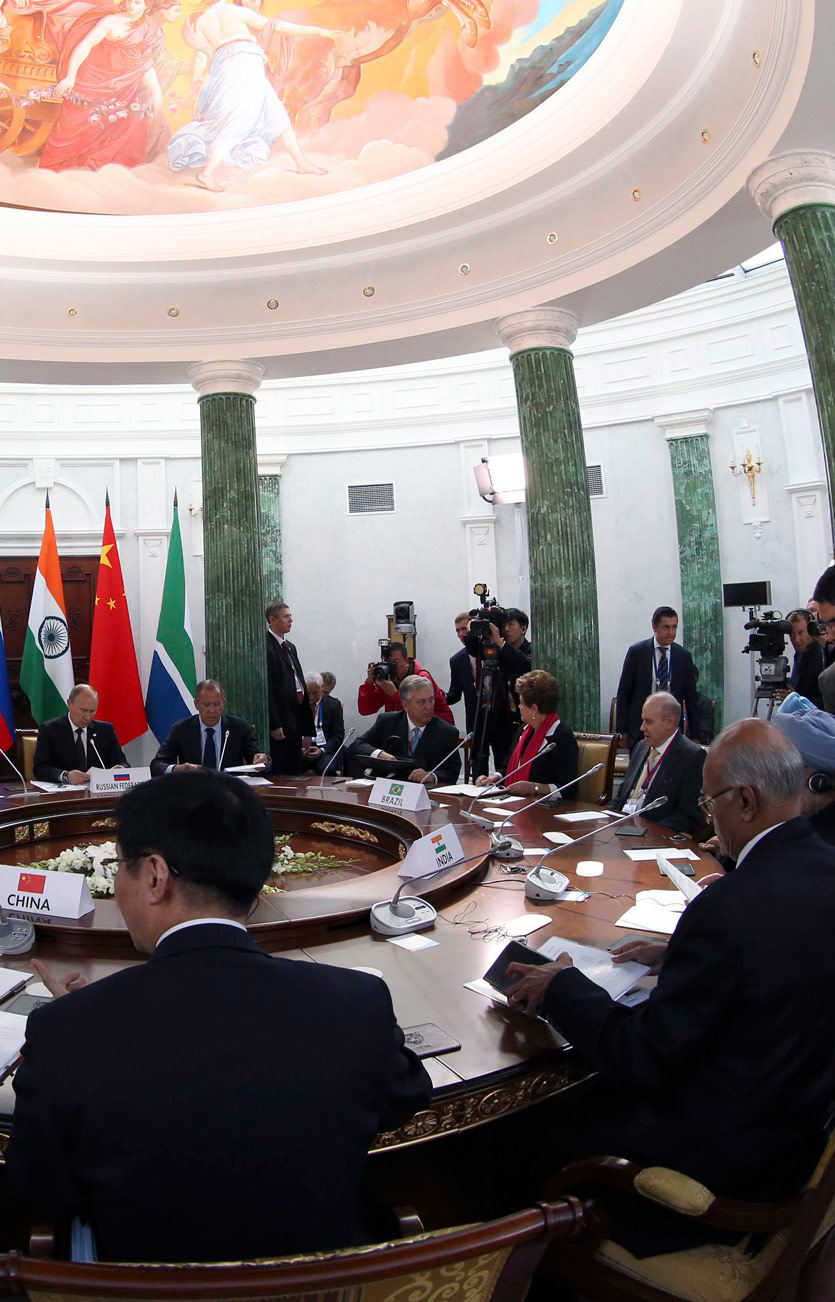 large conference table at which world leaders are seated, surrounded by press and their minions, a summit meeting with greek columns of marble and a traditional fresco in the dome above